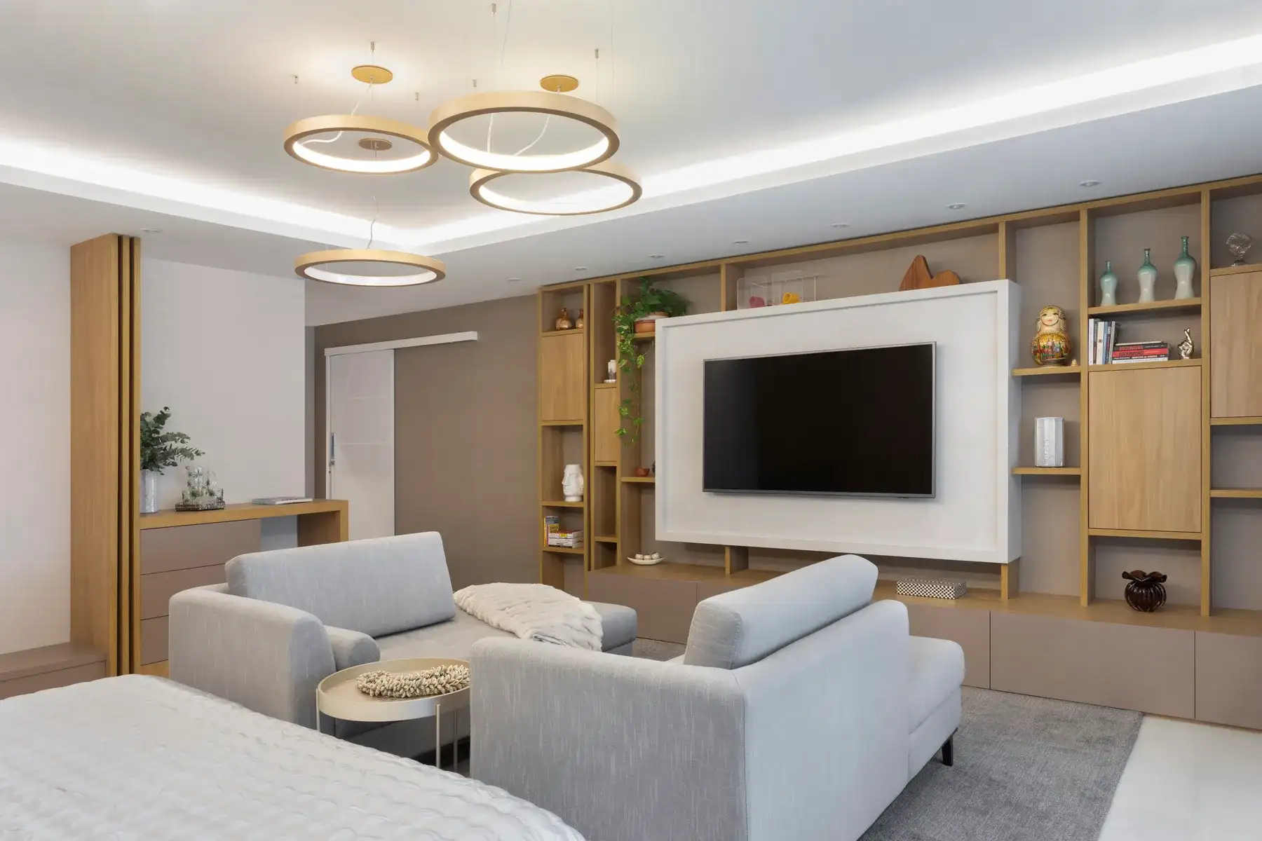 Media room in the HOME IT residence with ring pendant lighting, custom wood millwork and a built-in television